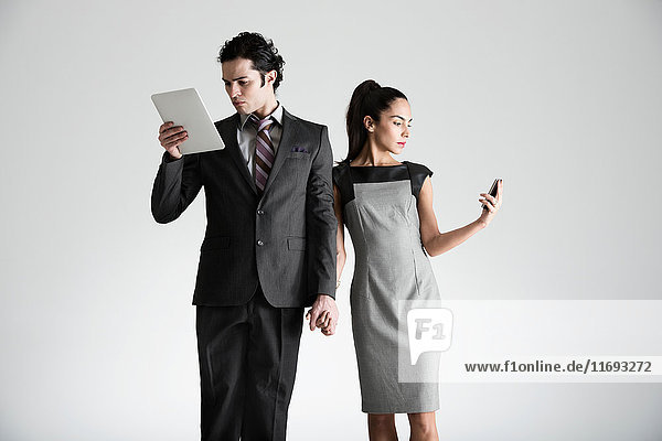 Mann mit digitalem Tablet  Frau am Handy