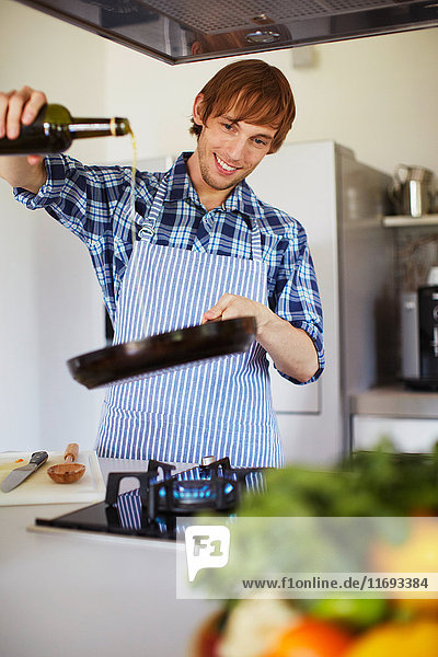 Man cooking with wine in kitchen