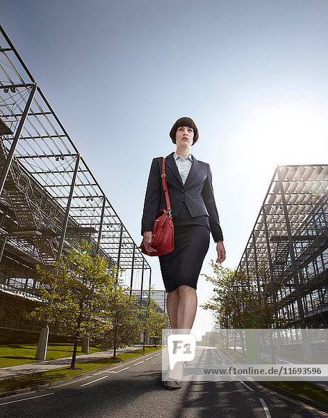 Oversized businesswoman walking on road  low angle view