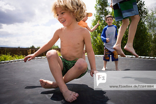 Jungen springen auf Trampolin im Freien