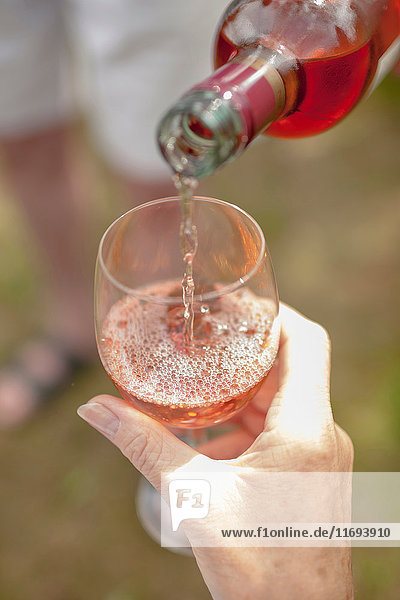 Woman pouring glass of wine outdoors