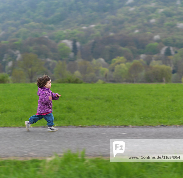 Junges Mädchen rennt den Fußweg entlang