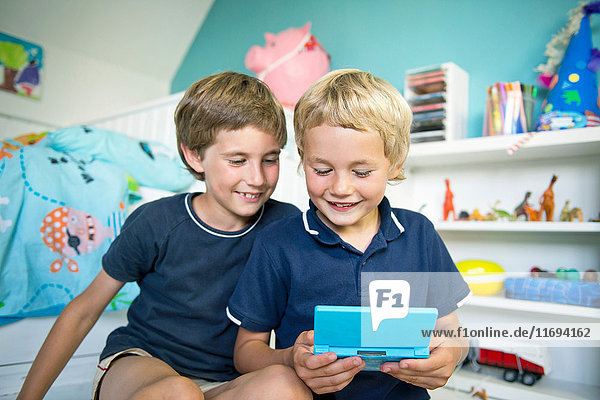 Brüder mit Handheld-Computerspiel