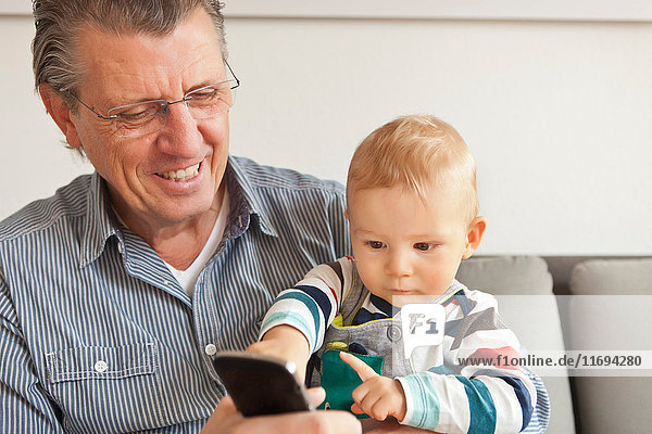 Mann mit Enkel telefoniert mit Handy