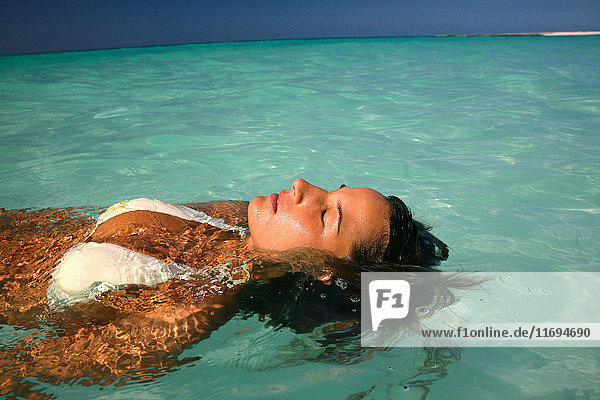 Woman floating in tropical water