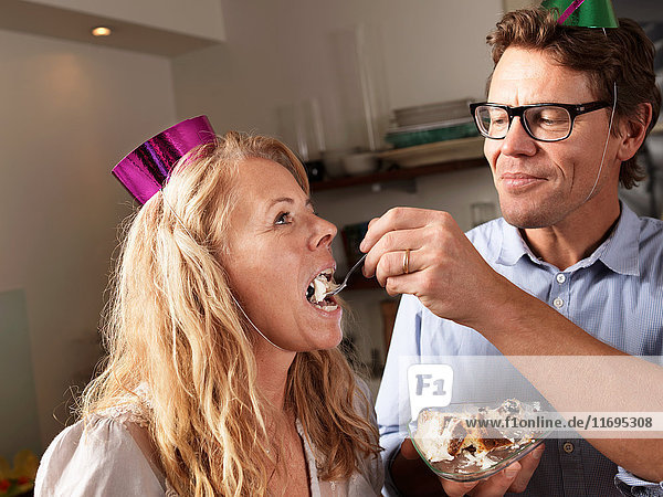 Reifer Mann füttert Frau mit Kuchen