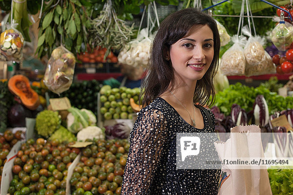 Frau kauft auf dem Markt im Gemüsehändler