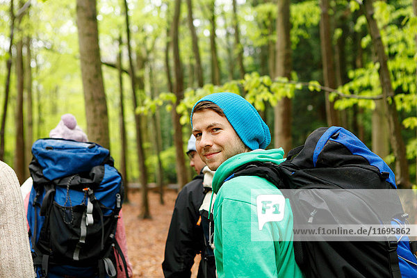 Smiling friends hiking in forest