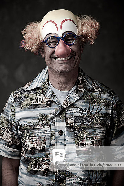 Portrait of a senior man wearing clown mask