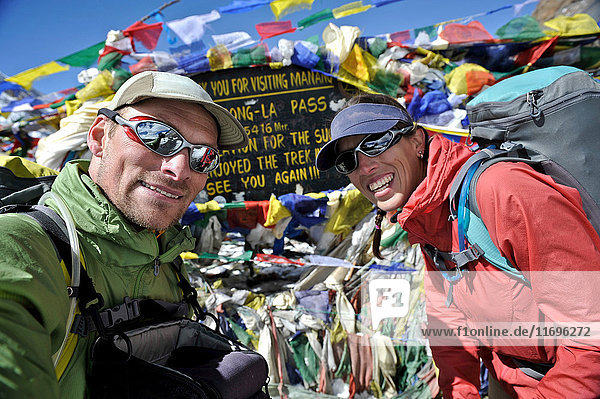 Trekker schauen in der Nähe von Gebetsfahnen in die Kamera  Thorung La  Nepal