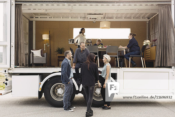 Geschäftsleute diskutieren mit einem tragbaren Office-Truck auf der Straße
