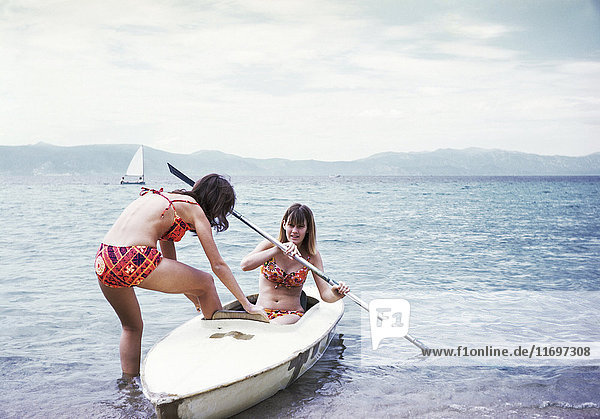 Caucasian girls in kayak on lake