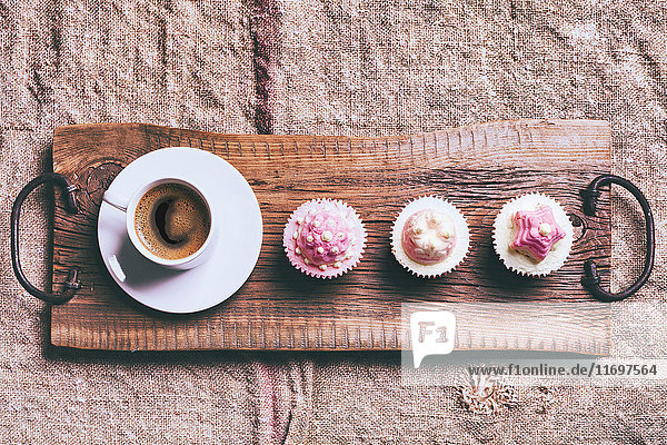 Coffee and cupcakes on wooden tray