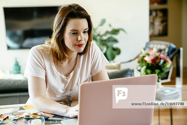 Woman sitting at table using laptop