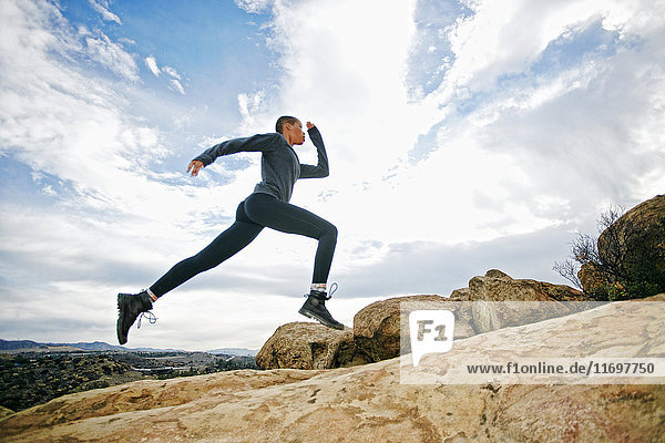 Black woman running on rock formation