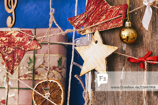 Ornamente hängen an einer Schnur in der Nähe der Geschenkbox
