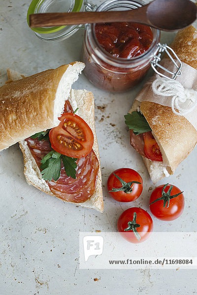Sandwich near tomatoes and jar
