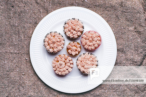 Nahaufnahme von Cupcakes mit rosa Zuckerguss auf einem Teller
