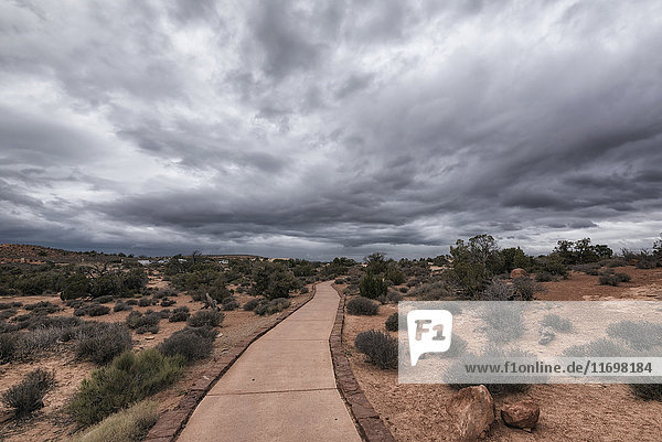 Path under clouds in Arches National Park Moab Utah United States