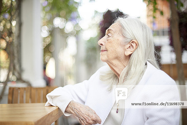 Profile of smiling older Caucasian woman sitting at table