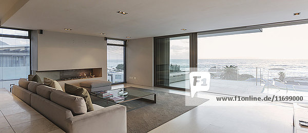 Modernes Luxus-Wohnzimmer mit Terrassentüren zum Meer und zur Terrasse