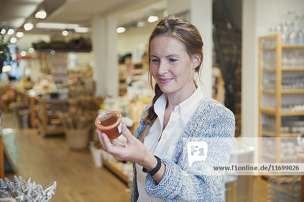 Woman shopping  reading label on jar of jam in shop