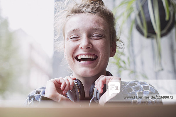 Porträt lachende junge Frau mit Kopfhörern