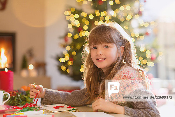 Porträt lächelndes Mädchen beim Basteln von Weihnachtsschmuck