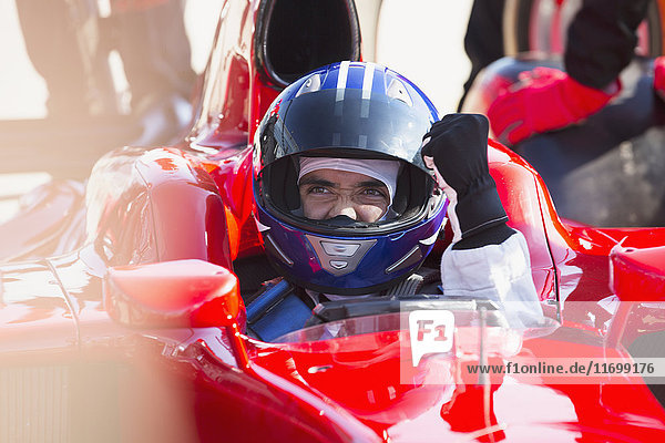 Formula one race car driver in helmet gesturing  celebrating victory