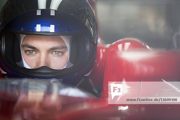 Nahaufnahme fokussierter Formel-1-Rennfahrer im Helm mit Blick in die Ferne