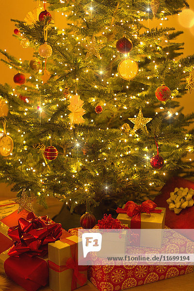 Beleuchteter Weihnachtsbaum mit Ornamenten und Geschenken