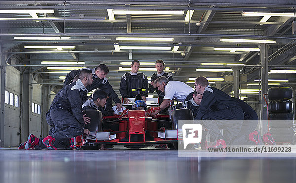 Race car team working on race car in garage