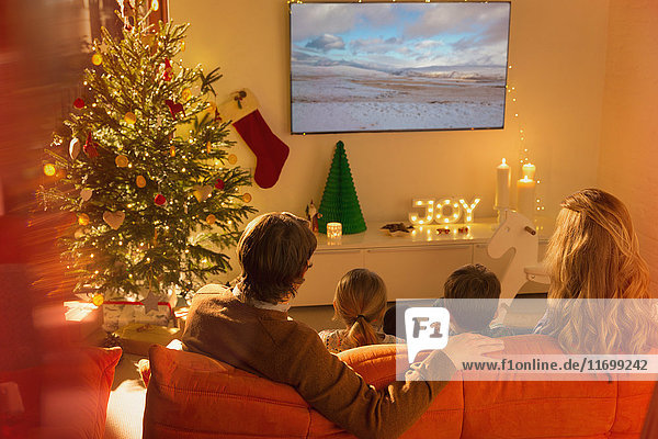 Familie beim Fernsehen im Weihnachtswohnzimmer