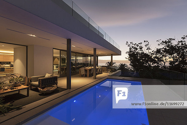 Ruhiger blauer Schoß Swimmingpool außerhalb des modernen luxuriösen Hauses Vitrine außen
