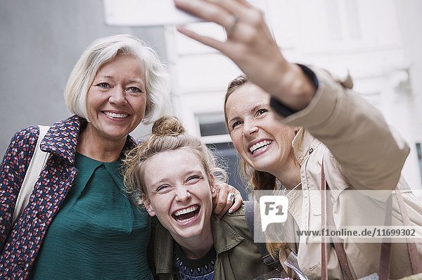 Laughing mother and daughters taking selfie