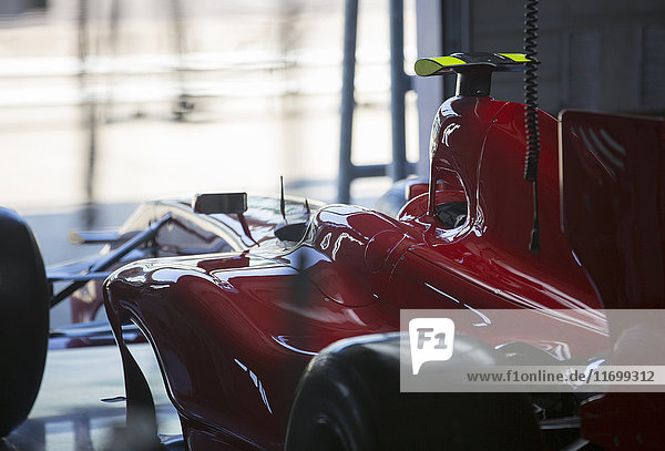 Red formula one race car in repair garage