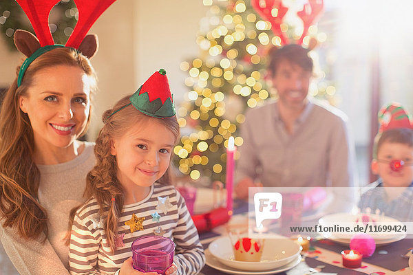 Porträt lächelnd Mutter und Tochter tragen Kostüm Rentiergeweih an Weihnachten Abendessen Tabelle