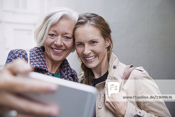 Lächelnde Mutter und Tochter nehmen Selfie mit Kamera-Handy
