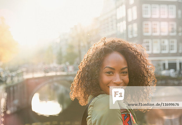 Portrait lächelnde junge Frau am Stadtkanal  Amsterdam