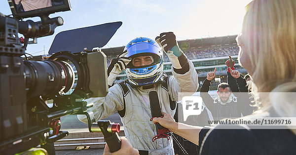 Nachrichtenreporter und Kameramann interviewt Formel 1 Fahrer jubelnd  feiert Sieg