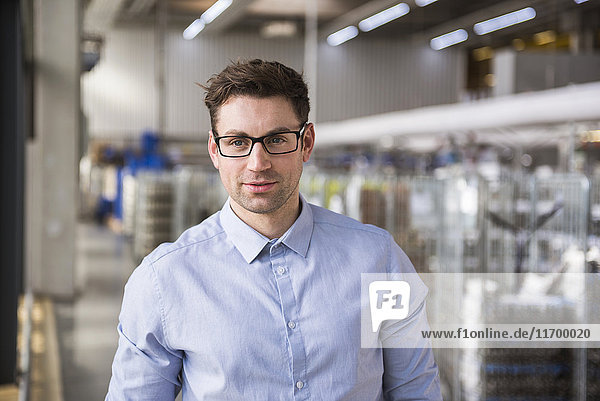 Portrait of confident businessman in factory shop floor