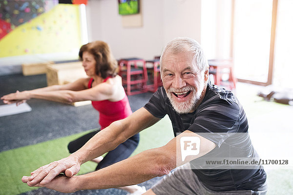 Senior man and woman exercising in gym