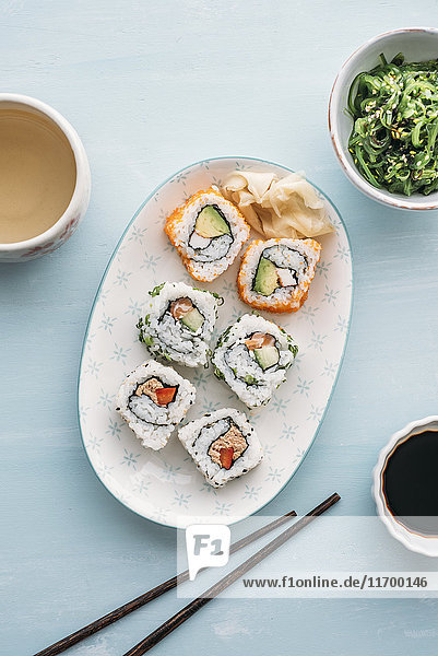 Sushi-Rollen auf einem Teller  Wakame-Algensalat und Grüntee