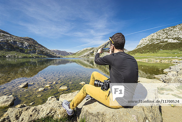 Spain  Asturias  Picos de Europa National Park  man taking picture at Lakes of Covadonga