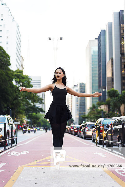 Brasilien  Sao Paulo  Balletttänzerin auf Zehenspitzen auf dem Radweg