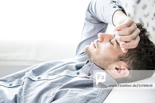 Man lying on couch with closed eyes