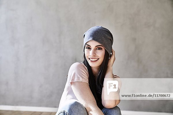Porträt einer lächelnden jungen Frau mit Mütze