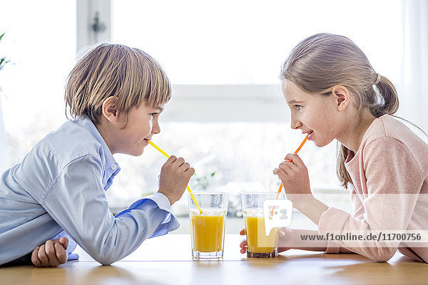 Bruder und Schwester trinken Orangensaft