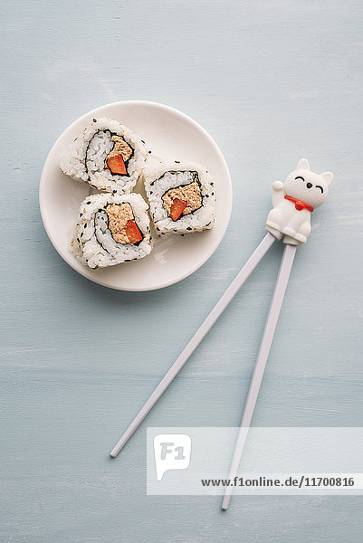 Sushi-Rollen auf einem Teller mit Stäbchen