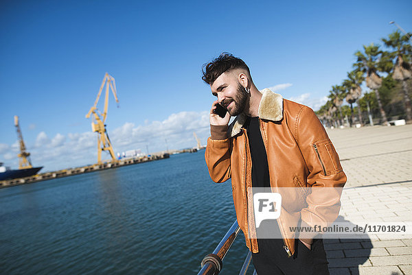 Spanien  Cadiz  Junger Mann am Hafen am Telefon